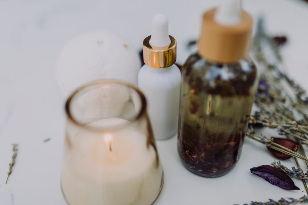 A calming spa setup featuring an aromatherapy candle, essential oils, and dried lavender for relaxation.